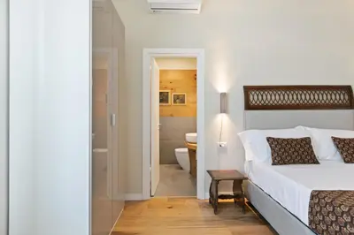a bedroom with a bed and a bathroom with a toilet at GuestHost - NotHotel Palermo Luxury Guest House in Palermo