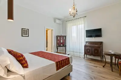 a bedroom with a bed and a table and a tv at GuestHost - NotHotel Palermo Luxury Guest House in Palermo