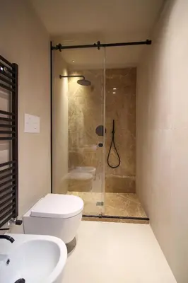 a bathroom with a shower and a toilet and a sink at Pànto - Rooftop boutique rooms in Palermo