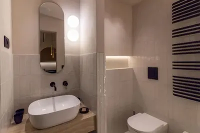 a bathroom with a white sink and a toilet at Pànto - Rooftop boutique rooms in Palermo