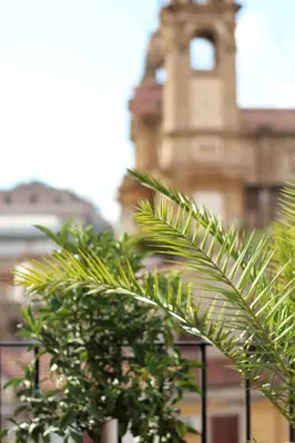 a group of palm trees in front of a building at Pànto - Rooftop boutique rooms in Palermo