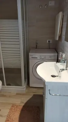 a bathroom with a sink and a washing machine at Appartamento francy in Castellammare del Golfo
