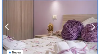 a bed with purple cabbage pillows on it at Appartamento francy in Castellammare del Golfo
