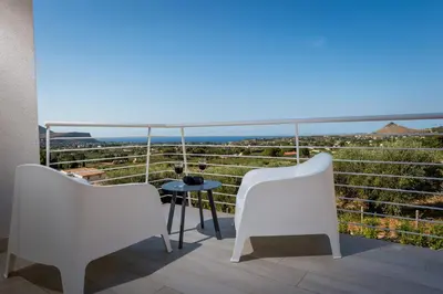 a balcony with two chairs and a table and a view at Giardino degli Allori - Villa Flores in Castellammare del Golfo