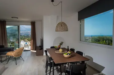 a dining room with a table and chairs and a large window at Giardino degli Allori - Villa Flores in Castellammare del Golfo