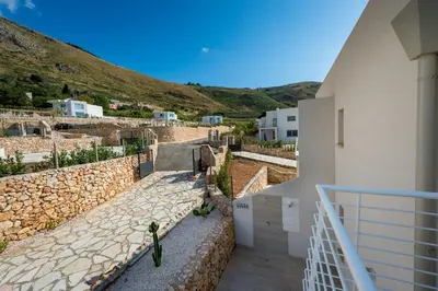 a view of a house with a stone wall at Giardino degli Allori - Villa Flores in Castellammare del Golfo