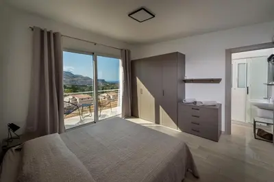 a bedroom with a bed and a bathroom with a sink at Giardino degli Allori - Villa Flores in Castellammare del Golfo