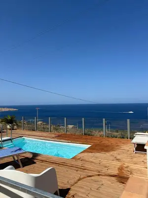 a swimming pool with a view of the ocean at Villa Costanza in San Vito lo Capo