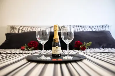 a bottle of champagne and two wine glasses on a table at La casa di Nana’ locazione turistica in Palermo
