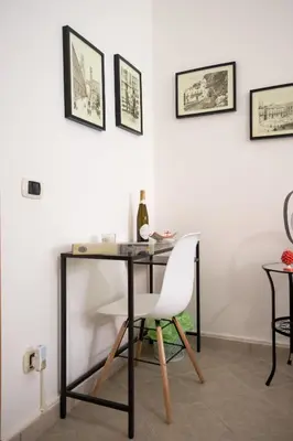 a desk with a white chair and a bottle of wine at La casa di Nana’ locazione turistica in Palermo