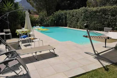 a swimming pool with chairs and a table next to it at Villa Tiziana in Monreale