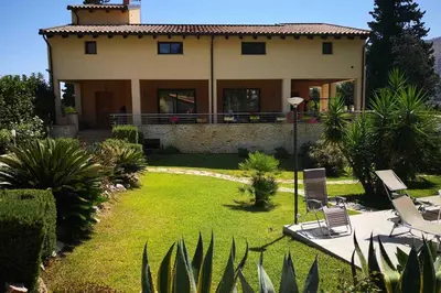 a house with a yard with chairs and plants at Villa Tiziana in Monreale