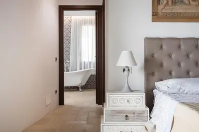 a bedroom with a bed and a bathroom with a tub at Villa a 300 Mt. dal Mare (Magaggiari) con campo da tennis in Cinisi