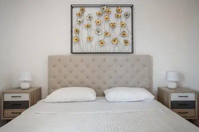 a bedroom with a bed with a headboard and two night stands at Villa a 300 Mt. dal Mare (Magaggiari) con campo da tennis in Cinisi