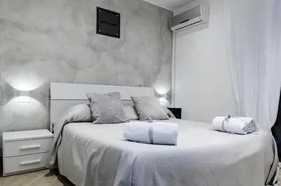 a bedroom with a large white bed with two pillows at Little House ai Tartari in Palermo