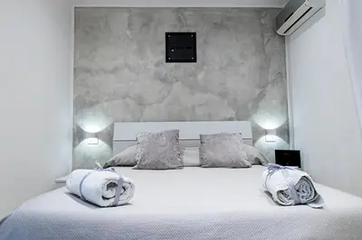 a bedroom with a white bed with towels on it at Little House ai Tartari in Palermo