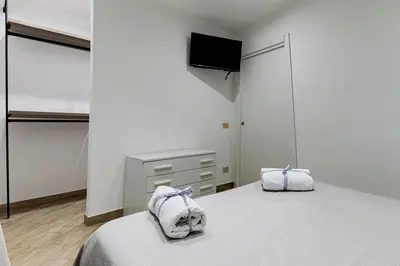 a bedroom with a bed and a tv on a wall at Little House ai Tartari in Palermo