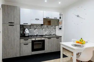 a kitchen with stainless steel appliances and a white table at Little House ai Tartari in Palermo