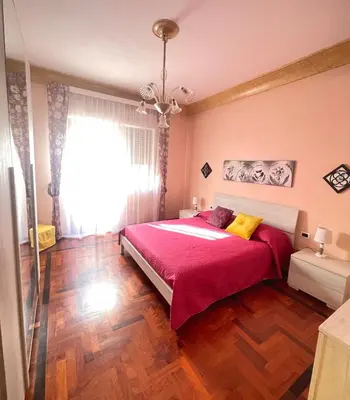a bedroom with a large bed with a red blanket at Casa Vacanza La Isla Bonita in Isola delle Femmine