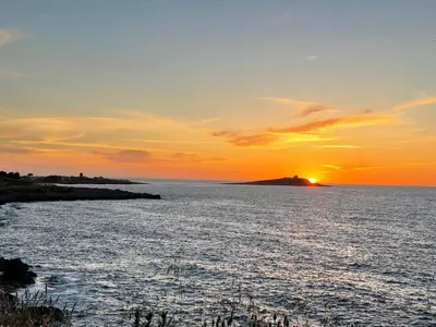 a sunset over a body of water with an island at Casa Vacanza La Isla Bonita in Isola delle Femmine