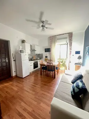 a living room with a couch and a kitchen with a table at Casa Vacanza La Isla Bonita in Isola delle Femmine
