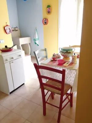 a small kitchen with a table and a chair at Appartamento centralissimo in Castellammare del Golfo