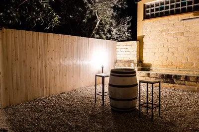 a lit barrel with two stools next to a fence at Villa Bienvenue in Carini