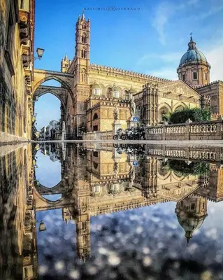 a reflection of a building and a bridge in the water at Suite Cathedral Palermo in Palermo