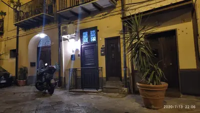 a house with a motorcycle and a plant in front of it at Rigoletto Holiday Home,Centrocittà Palermo in Palermo