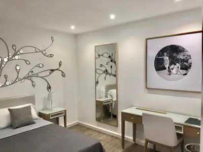 a bedroom with a bed and a desk and a mirror at SUITE 4 CANTI in Palermo