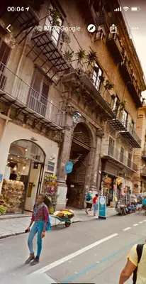 a person crossing a street in front of a building at SUITE 4 CANTI in Palermo