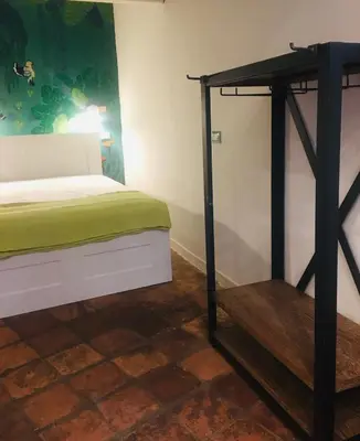 a bedroom with a bed with a green blanket at ne mia in Palermo