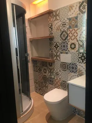 a bathroom with a toilet and a tiled wall at ne mia in Palermo