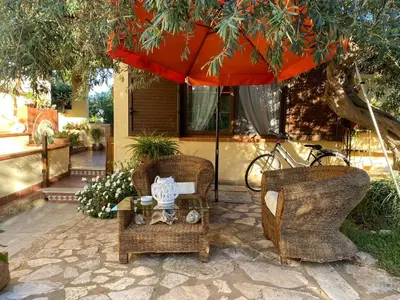 a patio with two chairs and a table with an umbrella at A casa di Eugenio in Carini