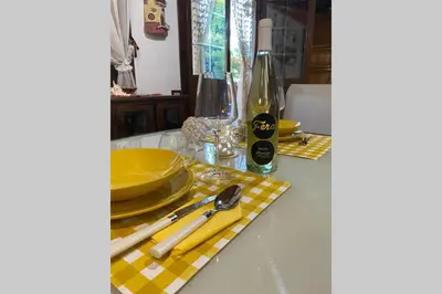 a table with yellow plates and silverware on a table at A casa di Eugenio in Carini