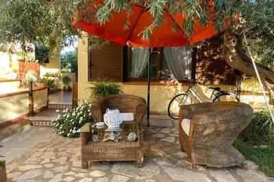 a patio with two chairs and a table and an umbrella at A casa di Eugenio in Carini