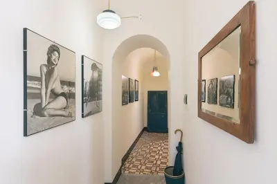 a hallway with pictures on the walls of a house at Dietro San Domenico Apartment in Palermo