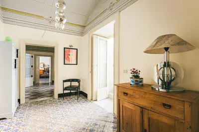 a room with a lamp on top of a wooden dresser at Dietro San Domenico Apartment in Palermo