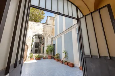 an open door of a building with potted plants at Dietro San Domenico Apartment in Palermo