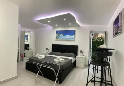 a bedroom with a bed and two bar stools at Rossella’s home in Palermo