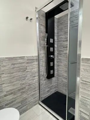 a shower with a glass door in a bathroom at Rossella’s home in Palermo