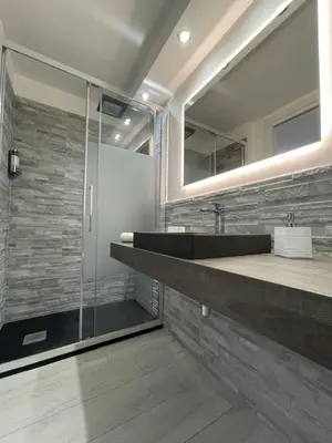 a bathroom with a sink and a glass shower at Rossella’s home in Palermo
