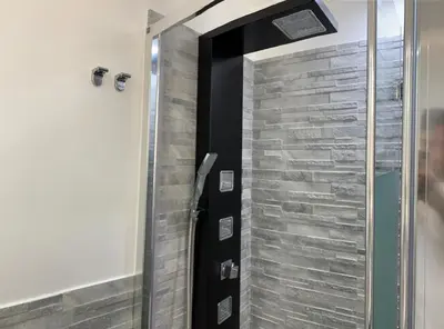 a shower with a glass door in a bathroom at Rossella’s home in Palermo