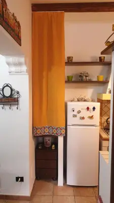a kitchen with a white refrigerator and an orange curtain at Home Casa Professa 1 in Palermo