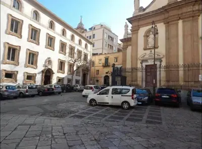 a white car parked in a parking lot next to a building at Home Casa Professa 1 in Palermo