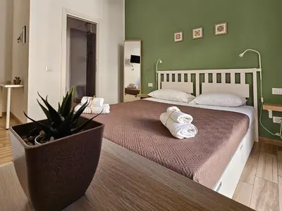 a bedroom with two beds with towels and a plant at Teatro Del Sole Apartment in Palermo