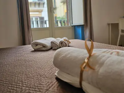 two towels on a bed in a room with a window at Teatro Del Sole Apartment in Palermo