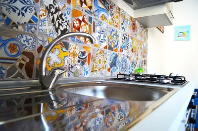 a sink in a kitchen with a tile wall at Le case di Ninni - Monfenera in Palermo