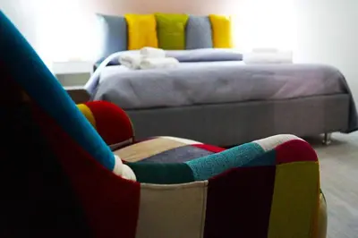 a bedroom with a bed and a chair and a couch at Le case di Ninni - Monfenera in Palermo