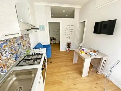 a kitchen and living room with a stove and a table at Le case di Ninni - Monfenera in Palermo